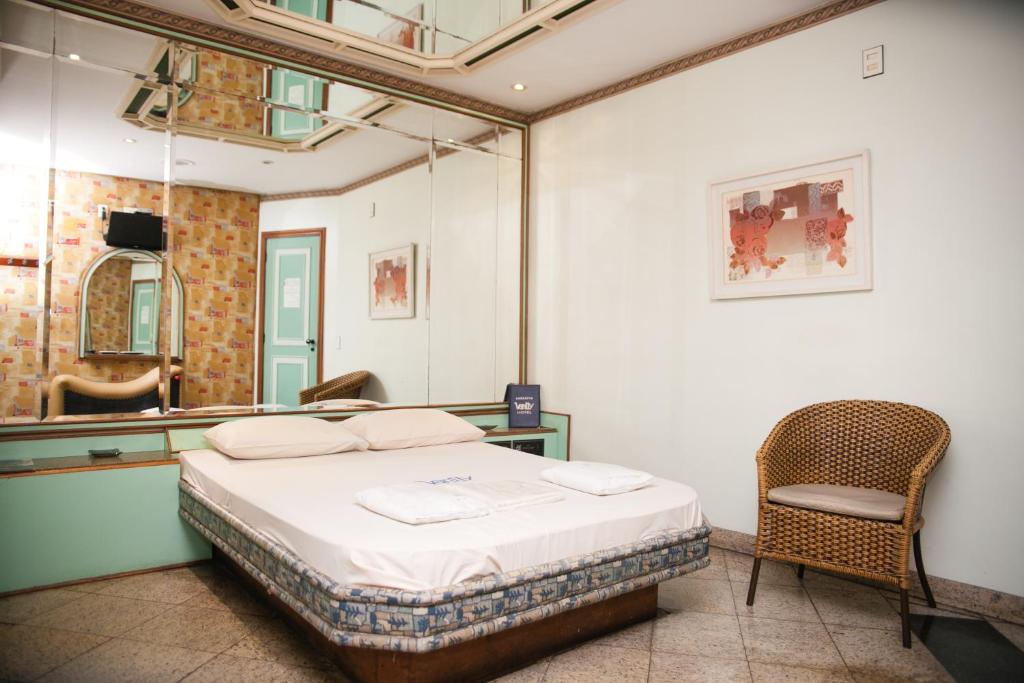 1 dormitorio con cama, silla y espejo en Hotel Vanity para adultos, en Río de Janeiro