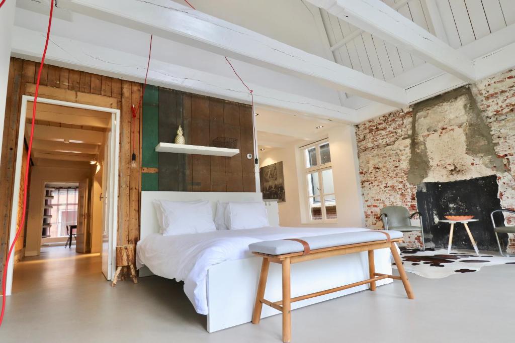 a bedroom with a white bed and a table at Luxe Loft Bierbrouwerij het Klavertje in Dokkum