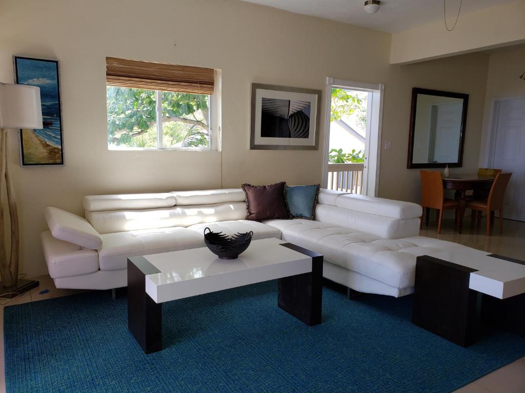 un soggiorno con divano bianco e tavolo di Villa Indigo Sunny 1BR Apartment in Private Gated Estate a Charlotte Amalie