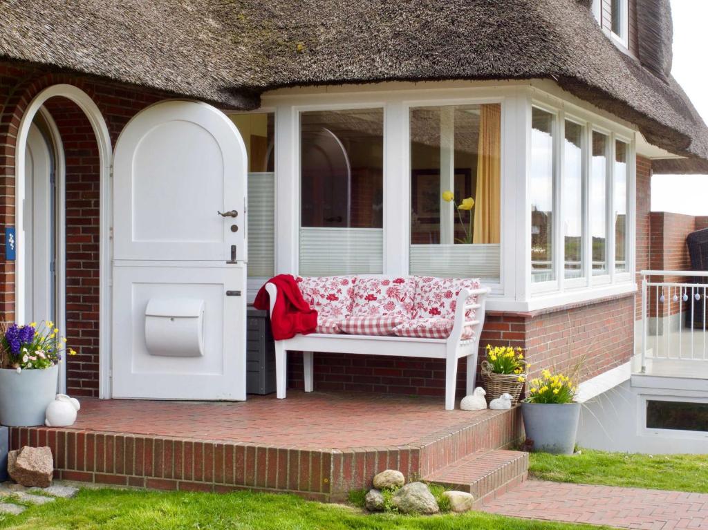 eine Veranda mit einer Bank auf einem Backsteinhaus in der Unterkunft Gästehaus Friedeburg in Rantum