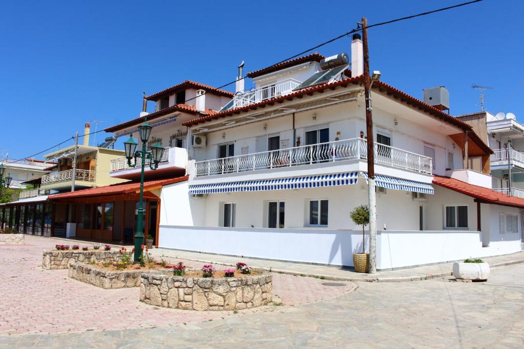 um edifício branco com varandas numa rua em Dream Apartments em Paralia Dionysiou