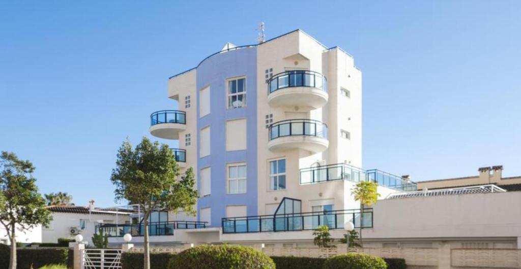 un edificio blanco con balcones en un lateral en Aguamarina Golf 3, en Oliva