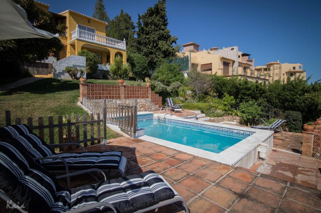 una casa con piscina en un patio en Villa La Tuna en Benalmádena