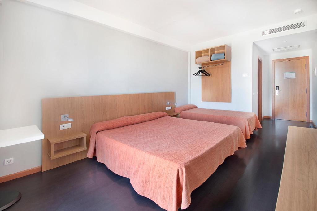 een slaapkamer met 2 bedden met oranje lakens bij AS Hoteles Ponferrada in Columbrianos