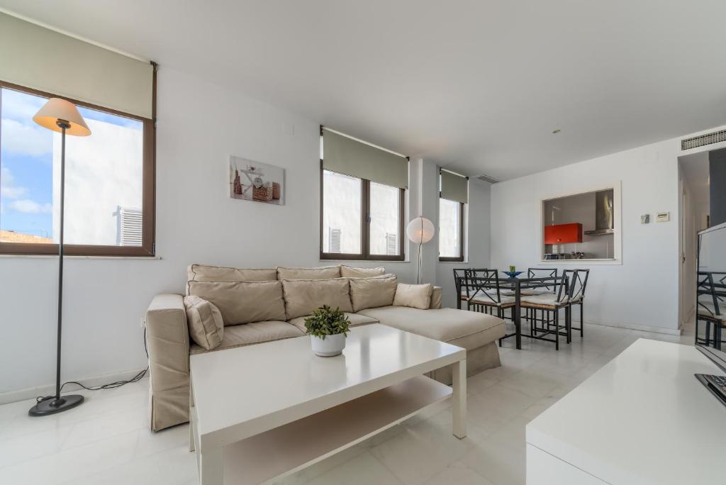 a living room with a couch and a table at Apartamentos Villas Flamenco Rentals in Conil de la Frontera