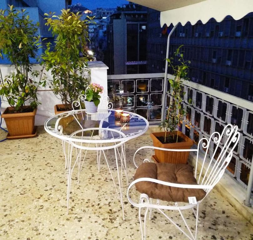 een balkon met een tafel, stoelen en planten bij Athena's Home, Sunny Balkony 100m from metro! in Athene