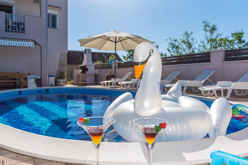 a swan inflatable swan in the middle of a pool at Villa Toni - Adriatic Luxury Villas in Zadar