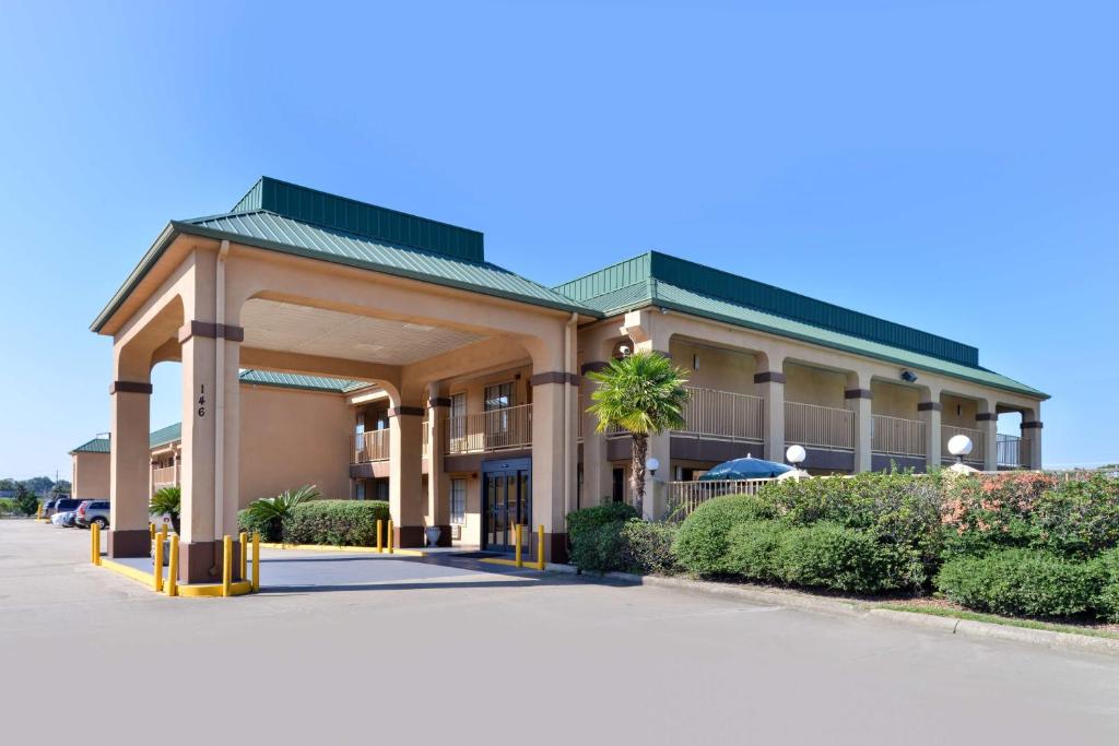 un hotel frente a un edificio con aparcamiento en Americas Best Value Inn Denham Springs, en Denham Springs