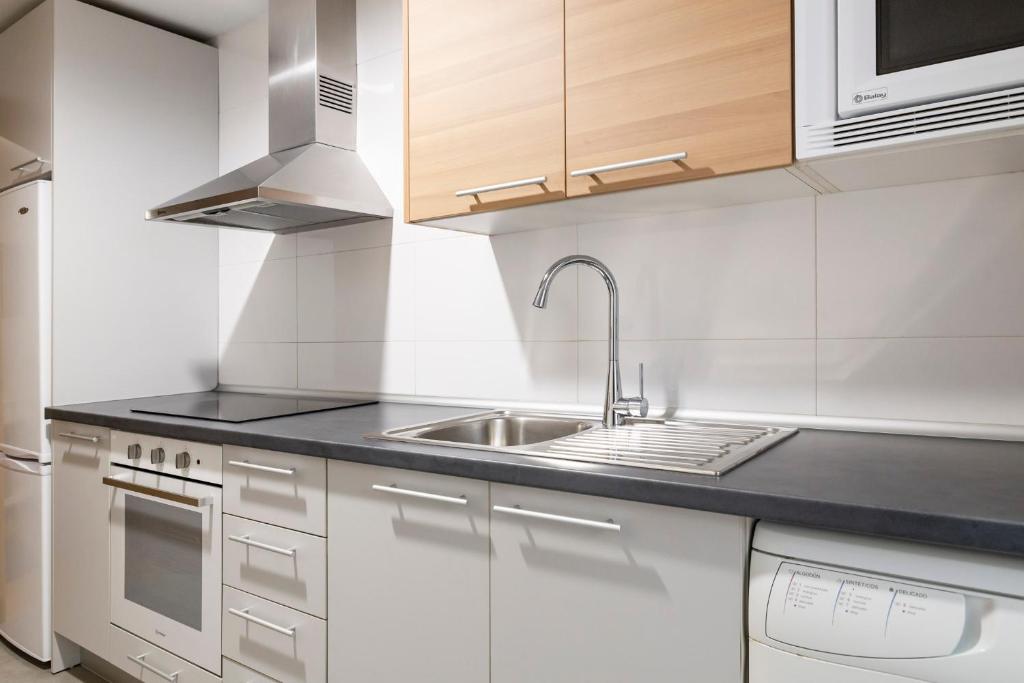 Biała kuchnia ze zlewem i kuchenką w obiekcie Apartamento Málaga Litoral Beach w Maladze