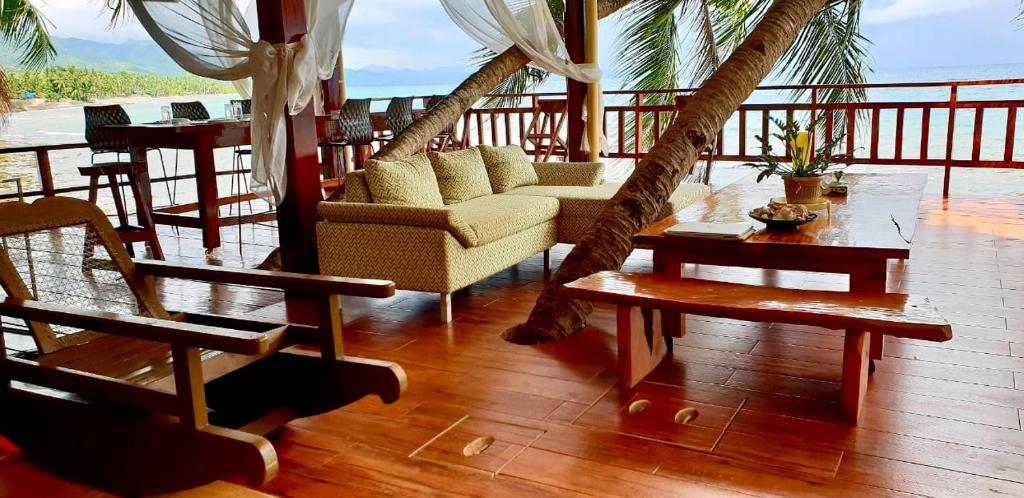 een woonkamer met een bank en hangmatten op een veranda bij Villa Naatang Bohol Beach House 1 in Jagna