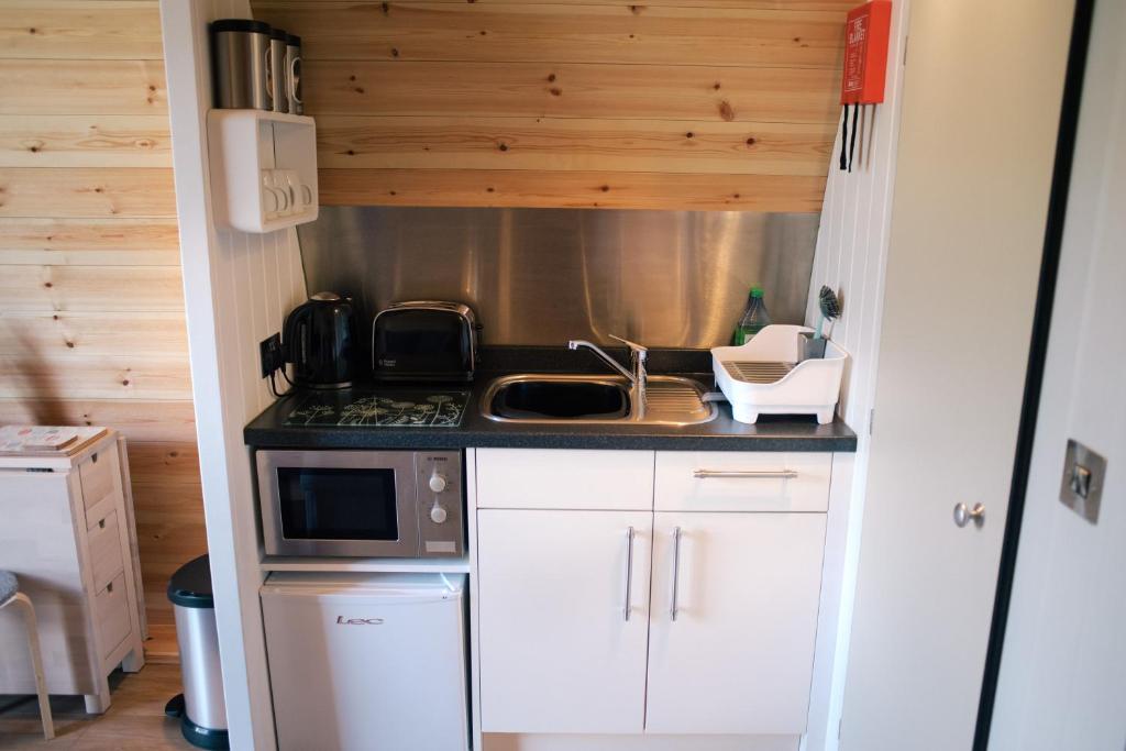 a small kitchen with a sink and a stove at Wensleydale Glamping Pods in Redmire