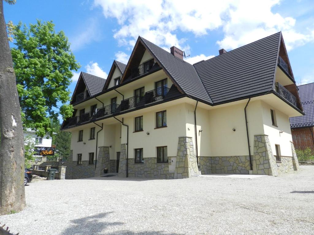 a large white building with a black roof at Willa Bella in Zakopane