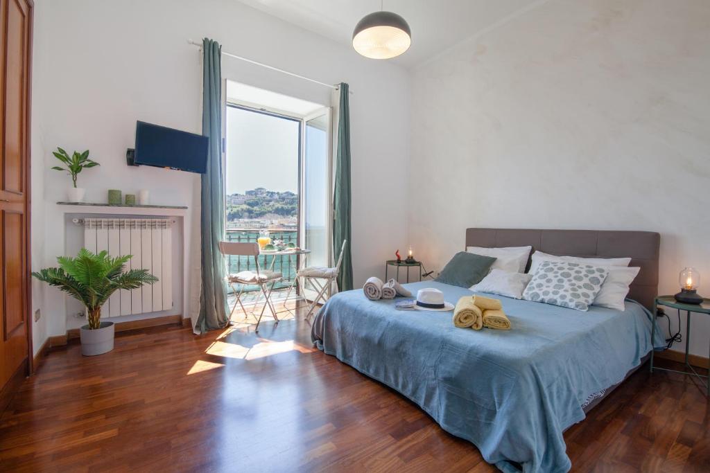 una camera da letto con un letto e una grande finestra di NapoliCentro Mare - Sea View Rooms & Suites a Napoli