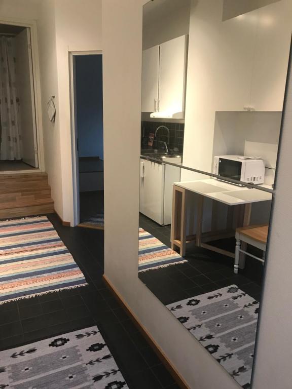 a kitchen with white cabinets and a table with a microwave at Målargatan 1 in Piteå