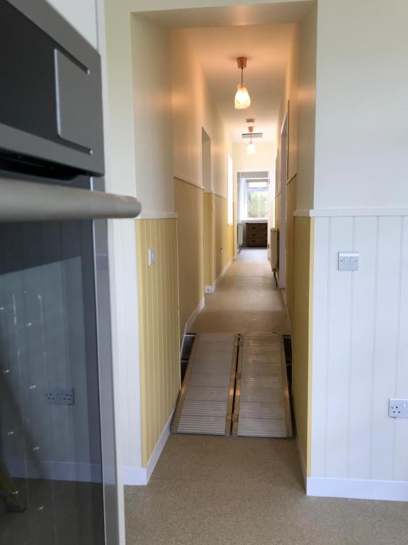 a hallway with a long corridor with wooden floors at Bayview Cottage, Dunnetbay accommodation in Thurso
