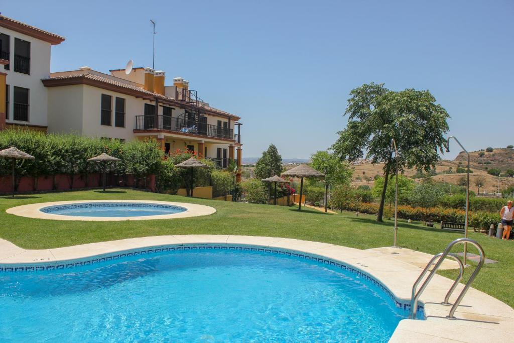 a swimming pool in a yard next to a house at HAA001) Apartamento moderno con jardín. in Ayamonte