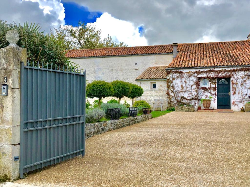 un portail en face d'une maison avec une clôture dans l'établissement Du Côté de l'Ombrière, à Geay