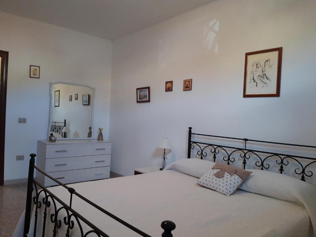 sypialnia z łóżkiem, komodą i lustrem w obiekcie CASA JUANNE iun P2043 w mieście Galtellì