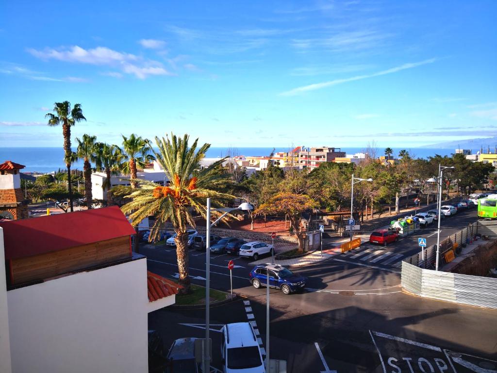 - une vue sur un parking avec des palmiers et l'océan dans l'établissement Relax in costa Adeje, à Adeje