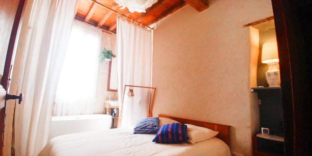 um quarto com uma cama, uma banheira e uma janela em At Home in Arles em Arles