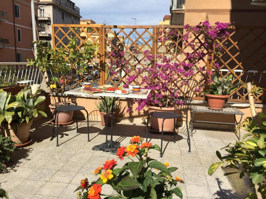un patio con flores, mesa y sillas en Alloggio Turistico via dei Faggi - Room en Roma