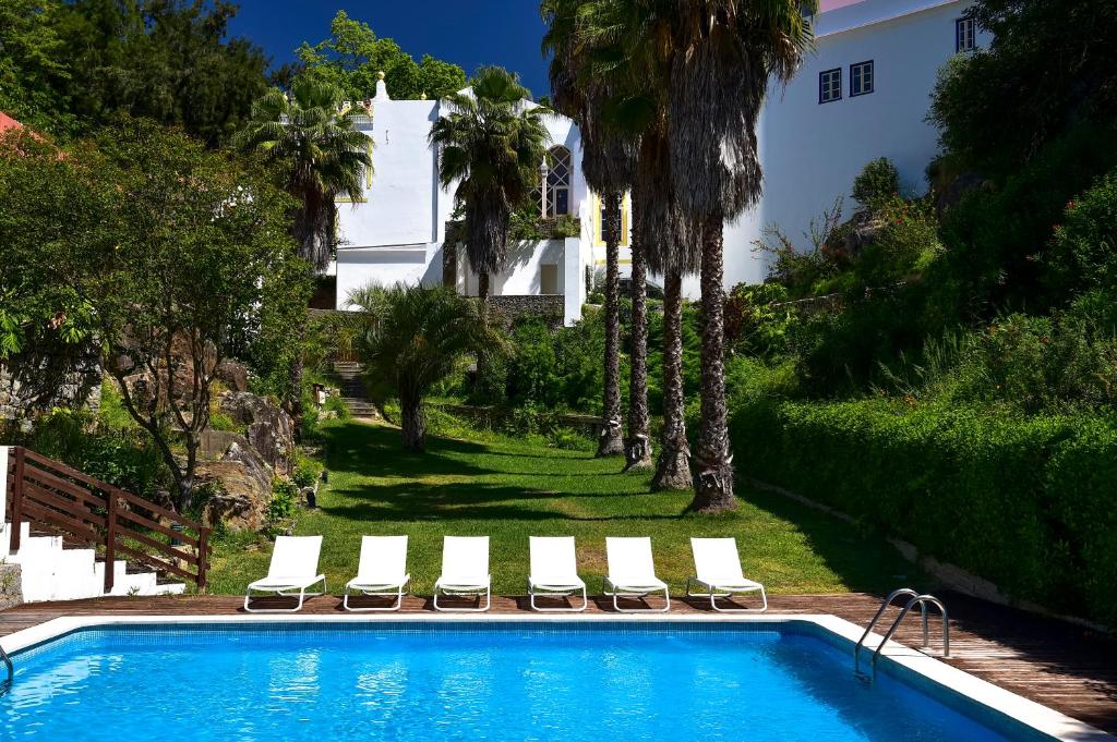 
a beach with a pool and lawn chairs at Villa Termal Monchique - Hotel Central - by Unlock Hotels in Monchique

