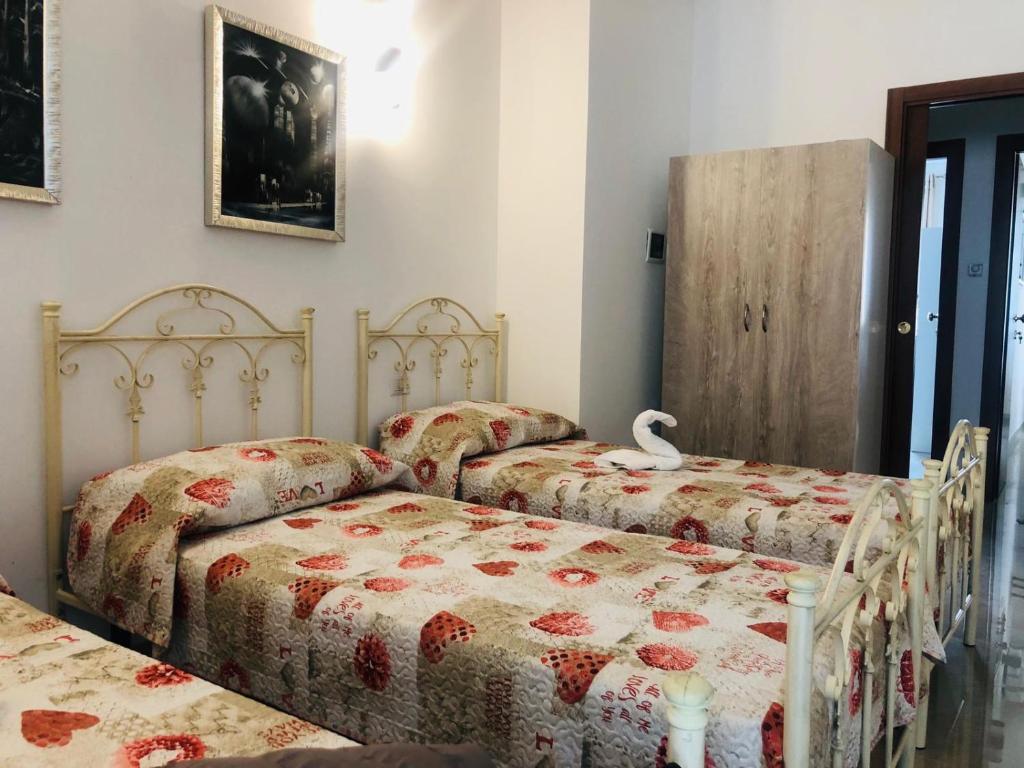 um quarto com duas camas e um cisne na cama em La casa di Chloé em Alezio