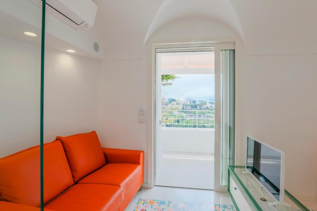 - un canapé orange dans le salon avec une fenêtre dans l'établissement The Lodge, à Scala