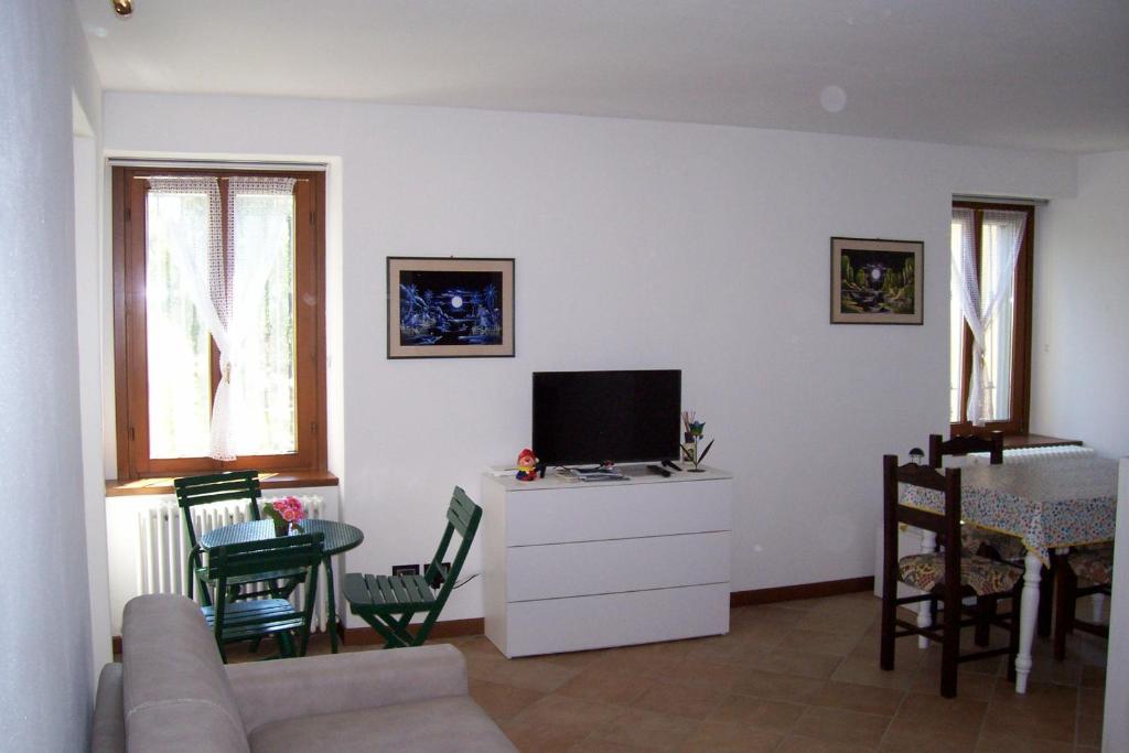 sala de estar con sofá y TV en Appartamento Contrada Vecchia, en Varenna