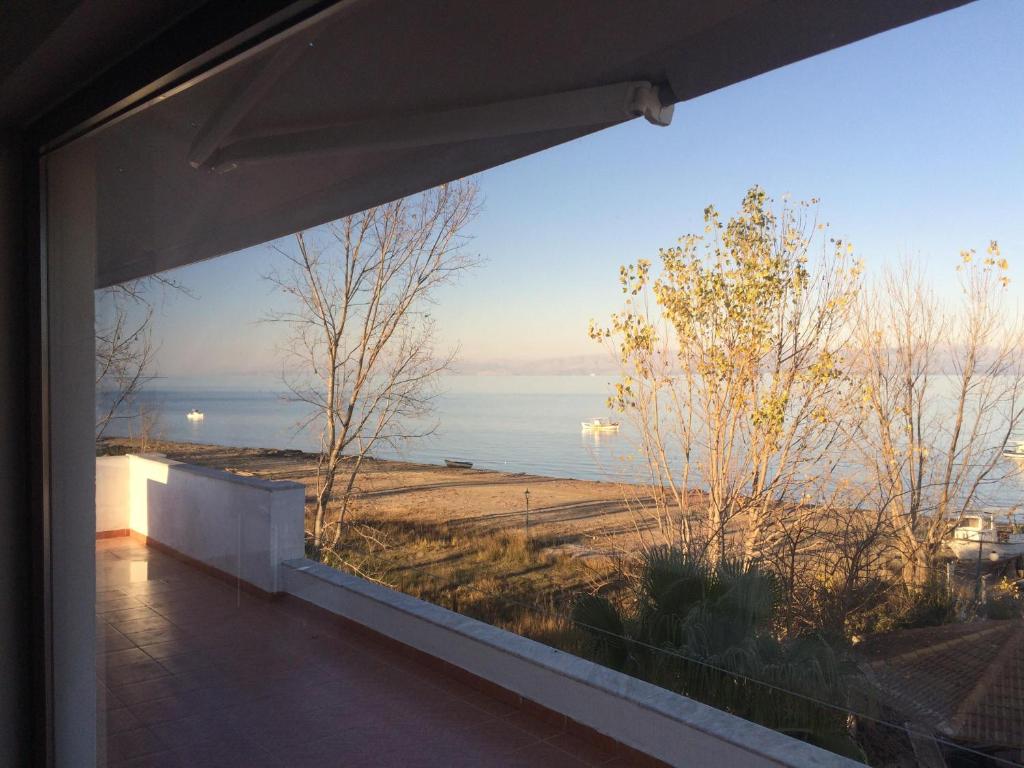 a view of the ocean from a window of a house at Hebes on the beach in Kavos