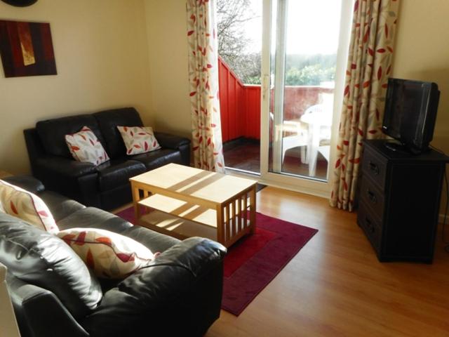 a living room with a couch and a coffee table at Oak Lodge in Pembrokeshire