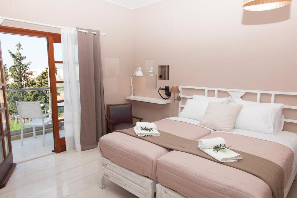 a bedroom with a large bed with two towels on it at Mojito Elegant Studios in Plataniás