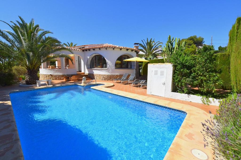 a swimming pool in front of a villa at Casa Mozart in Jávea