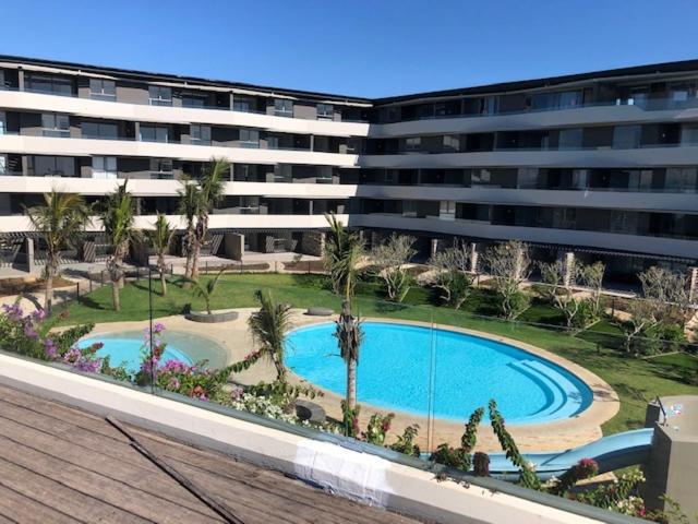 a large building with a swimming pool in front of a building at APARTMENT 246, PEBBLE BEACH, 12 HELEZA BOULEVARD, SIBAYA in Sibaya