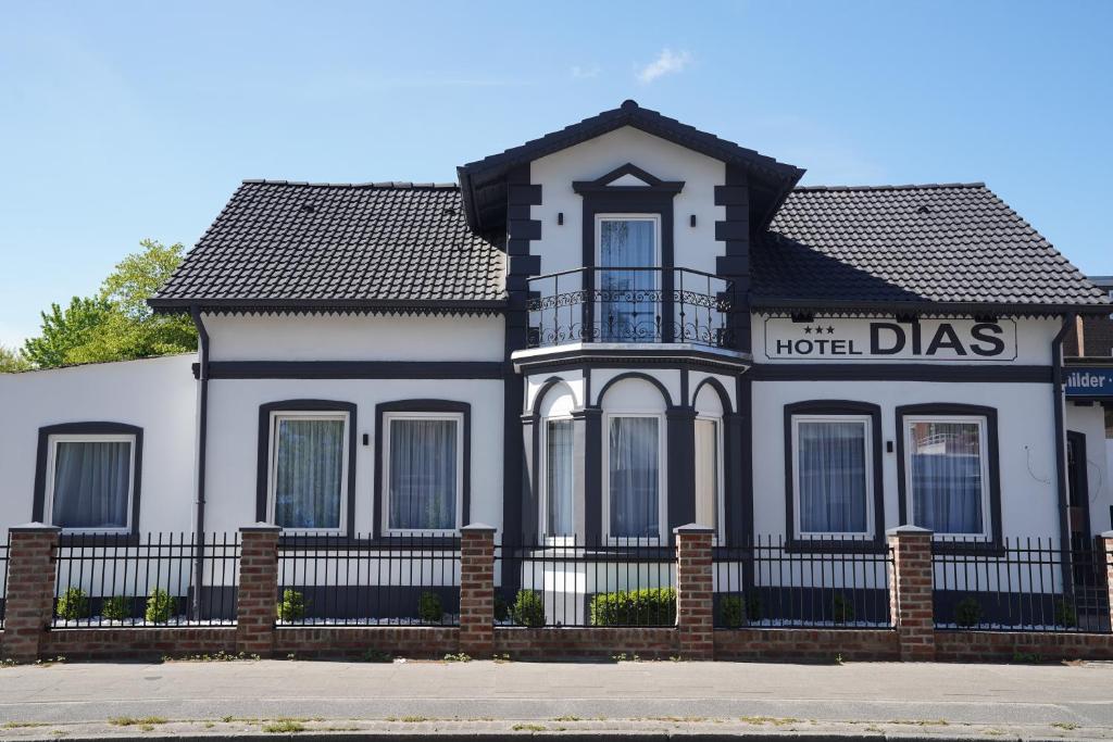 a house with a black fence in front of it at Hotel Dias in Pinneberg