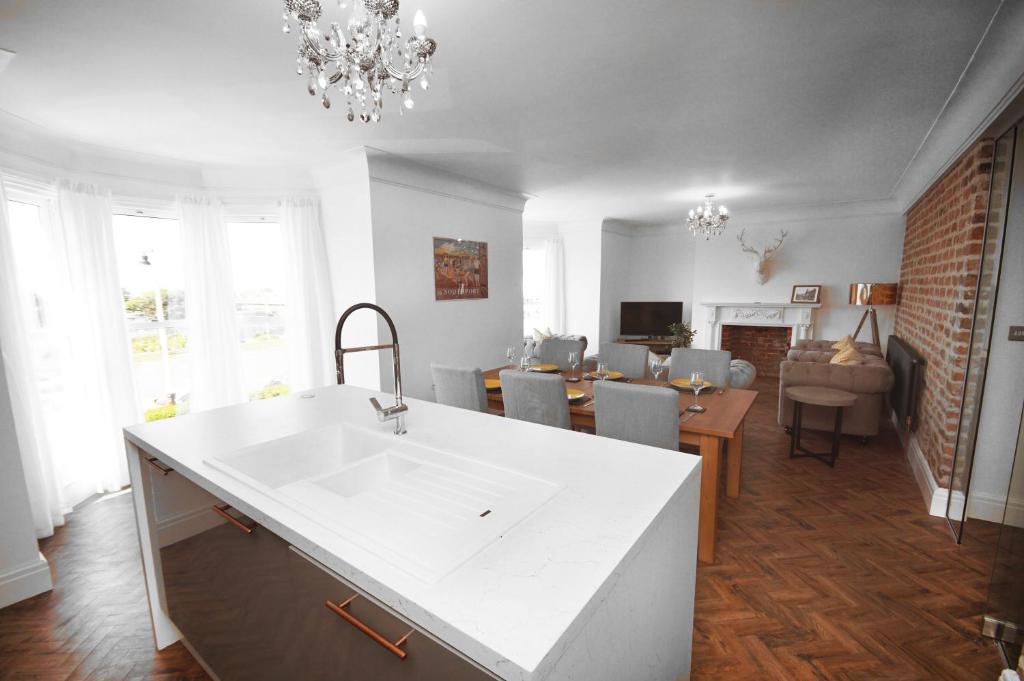 a kitchen with a sink and a living room at Grade 2 Listed Apartment, Southport Promenade in Southport