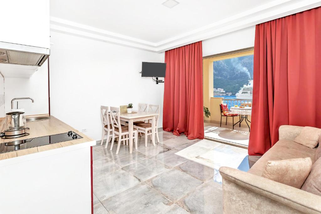 a kitchen and a living room with red curtains at Apartments Castello in Kotor