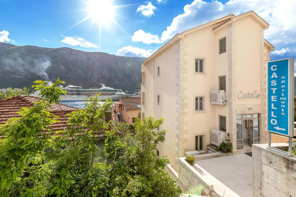 a building with a sign and a cruise ship in the background at Apartments Castello in Kotor