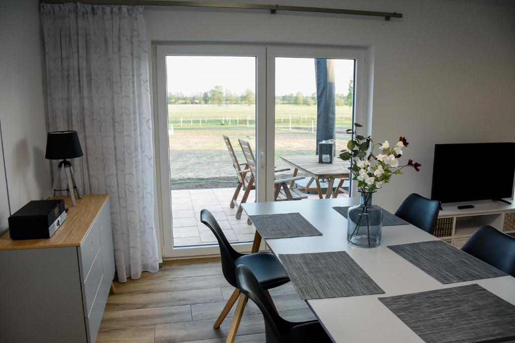 ein Esszimmer mit einem Tisch, Stühlen und einem Fenster in der Unterkunft Barrierefreie Ferienwohnung Trüben (Zerbst/Anhalt) in Trüben