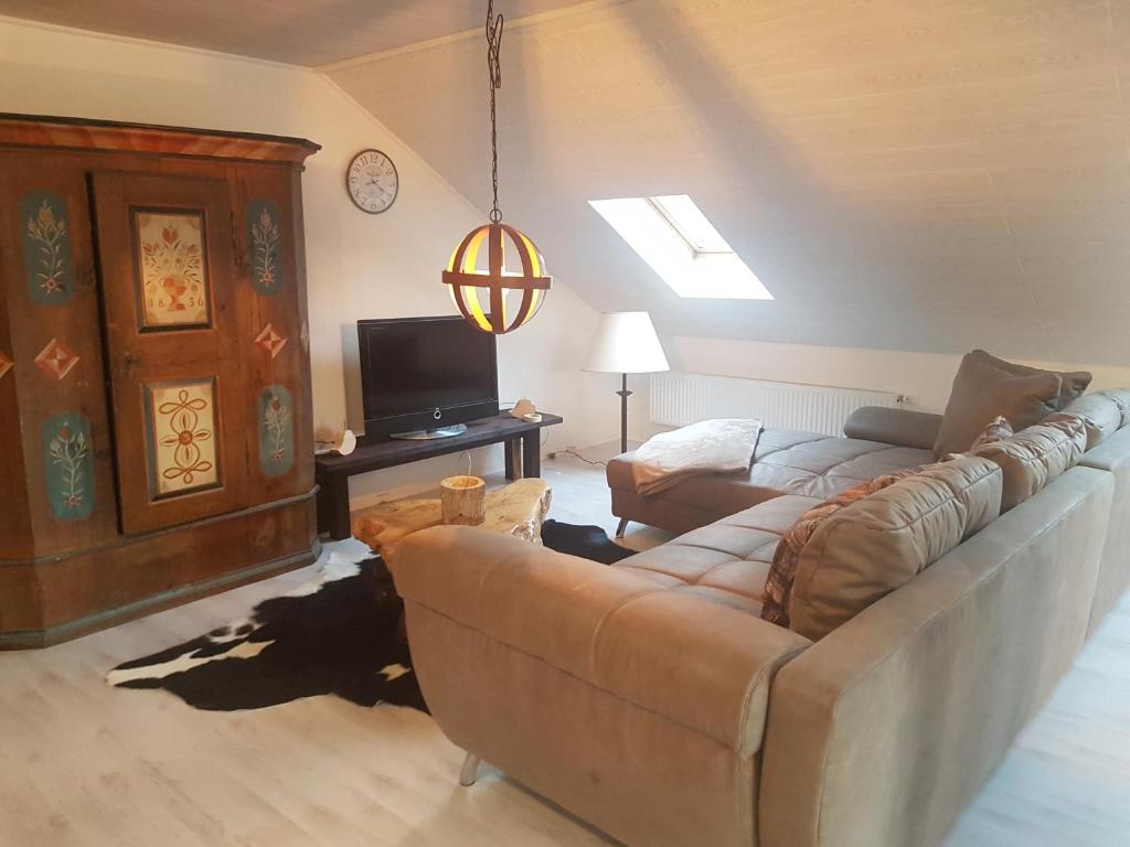 ein Wohnzimmer mit einem Sofa und einem TV in der Unterkunft Ferienwohnung Klothilde in Dietingen