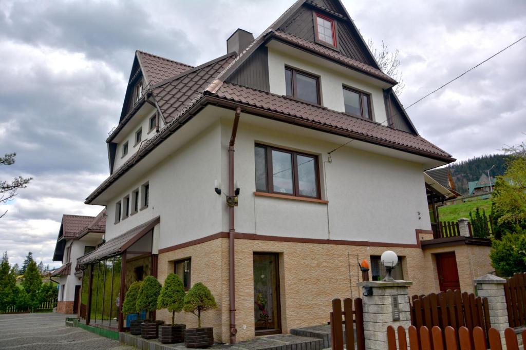 Casa blanca con techo marrón en Apartament Anna en Zakopane