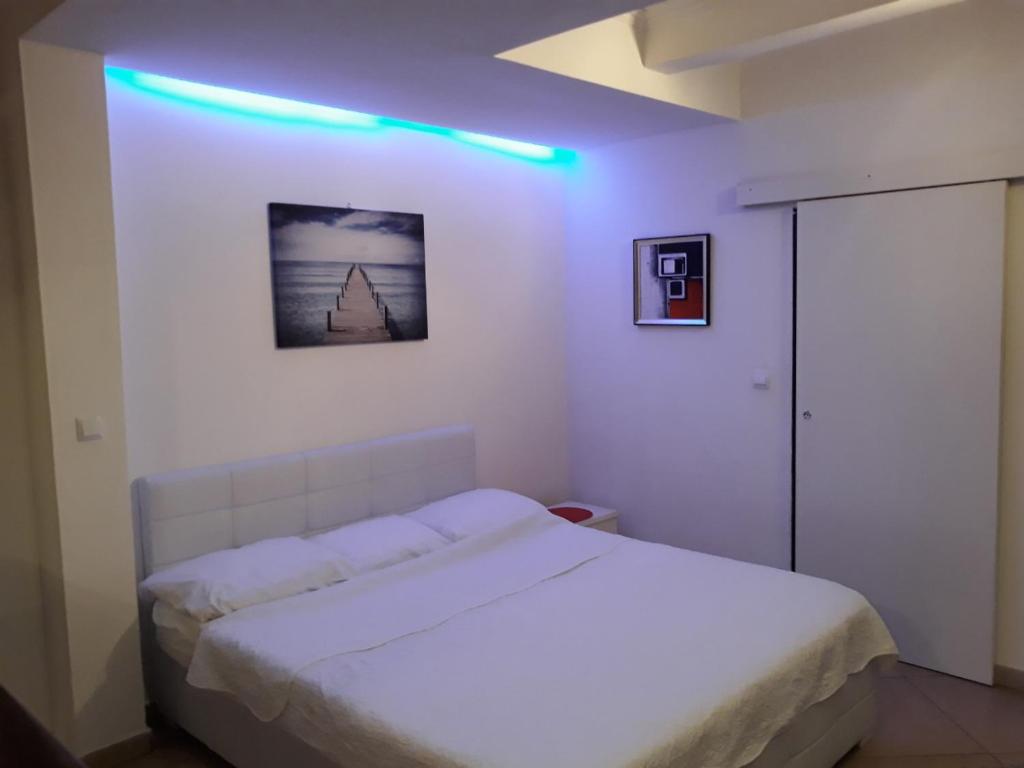 a bedroom with a white bed and a blue light at Studio Apartment Vukic in Dubrovnik