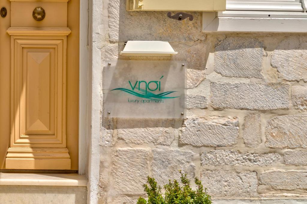a sign on the side of a brick building at Island of Luxury Apartments in Ermoupoli