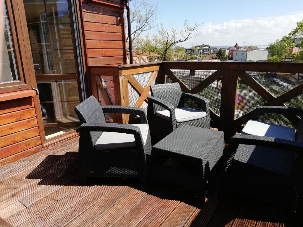 a group of chairs sitting on a deck at Apartamenty Turkusowe in Rowy