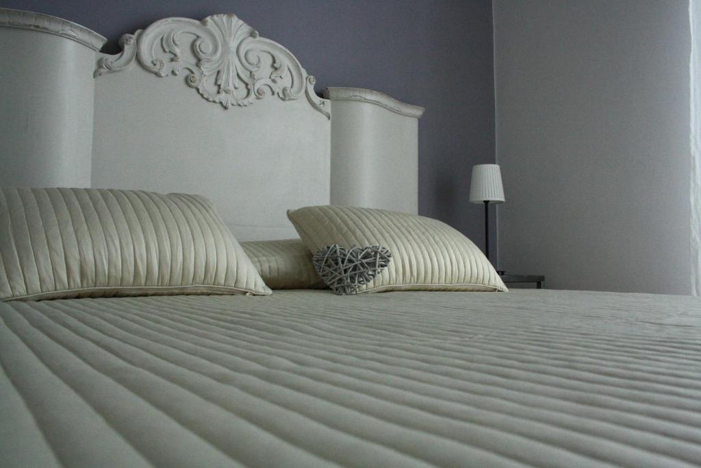 a large white bed with two pillows on it at Dimora Sabatini B&B in Oriolo Romano