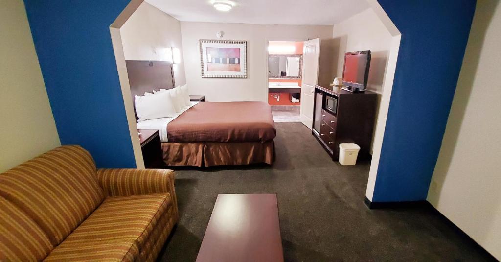 a hotel room with a bed and a couch at Executive Inn in Pensacola