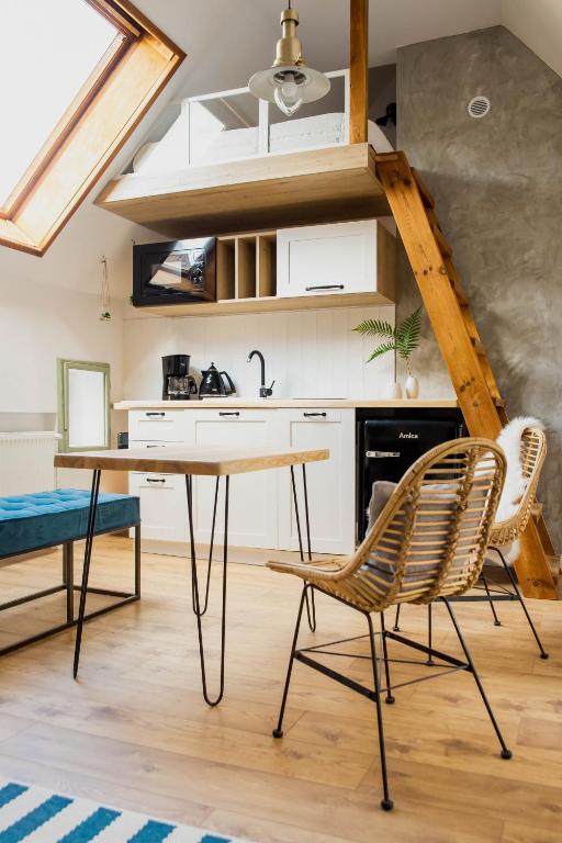 a kitchen with a table and chairs in a room at Skyway Apartment in Toruń