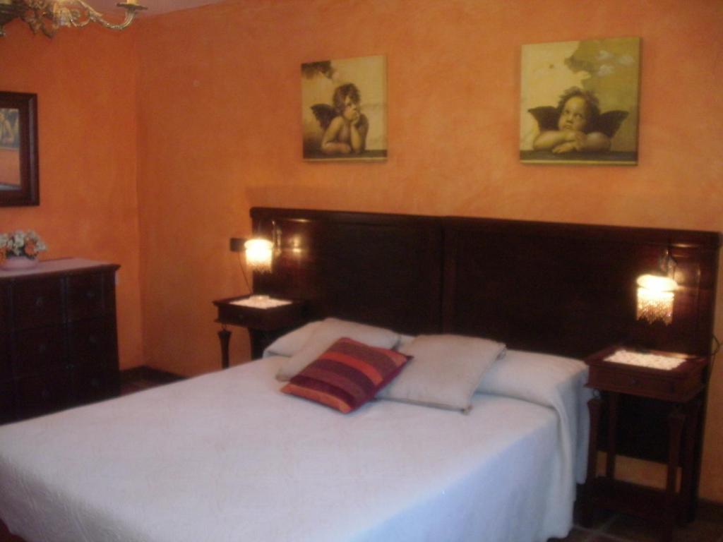1 dormitorio con 1 cama blanca grande y 2 lámparas en La Corralata, en Biescas