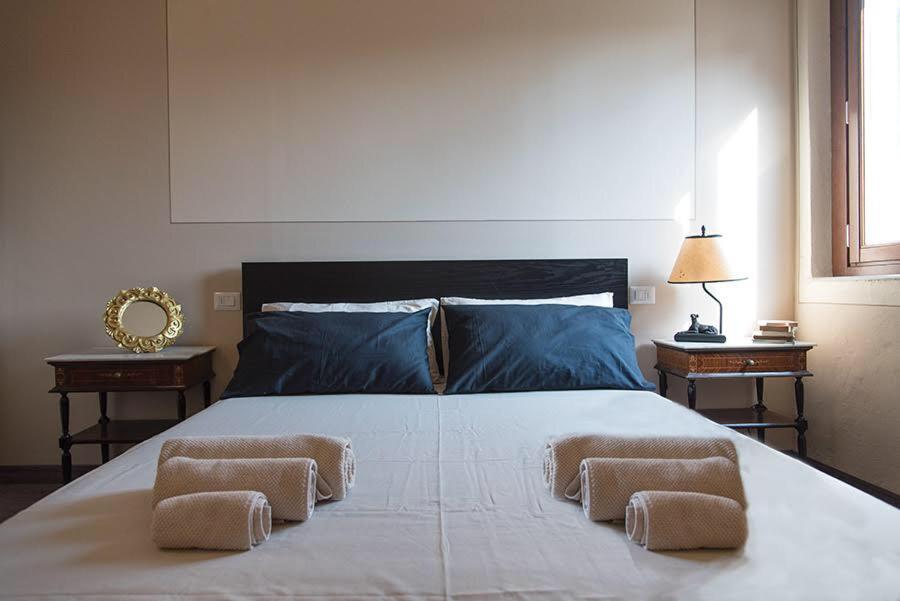 ein Schlafzimmer mit einem großen Bett mit zwei Tischen in der Unterkunft Affittacamere Come a Casa in Borgo a Buggiano