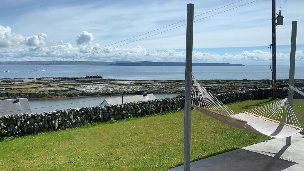 a hammock hanging from a pole next to the ocean at Cliffs of Moher View in Inisheer